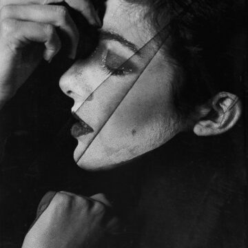 Black-and-white surrealist portrait of a woman’s face partially veiled and overlaid with textures, suggesting fragmentation and duality; her closed eyes, glitter makeup, and contemplative pose evoke themes of gender performance, self-objectification, and the tension between internal identity and external appearance — reflecting Simone de Beauvoir’s idea that “one is not born, but rather becomes, woman.”