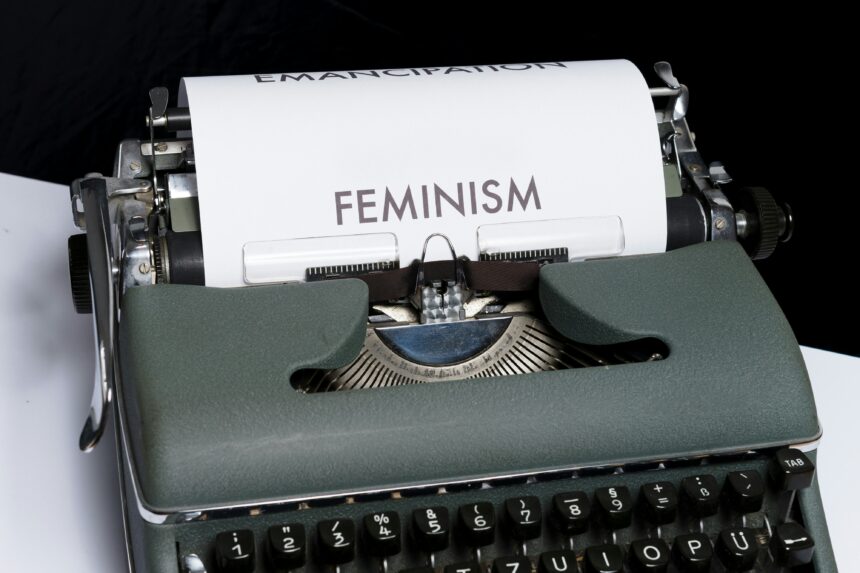 a vintage typewriter with the word "feminism" typed onto white paper