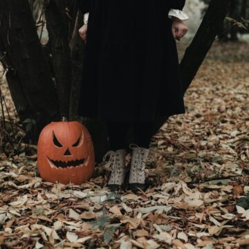 ksenia-yakovleva-EdWsF6rhyII-unsplash a spooky image of a vintage style woman standing next to a jack-a-lantern