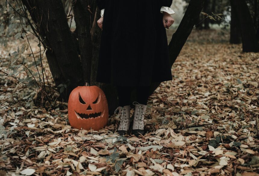 ksenia-yakovleva-EdWsF6rhyII-unsplash a spooky image of a vintage style woman standing next to a jack-a-lantern