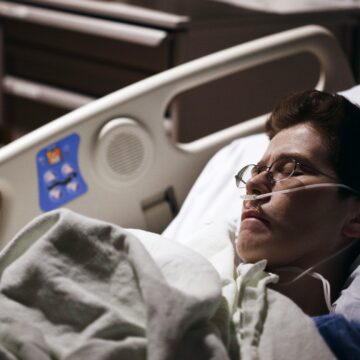 photo of someone in a hospital bed in a dimly lit room