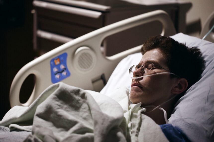 photo of someone in a hospital bed in a dimly lit room