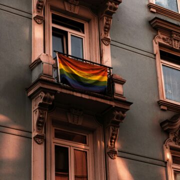 photo of a pride flag hanging from a building in s European city